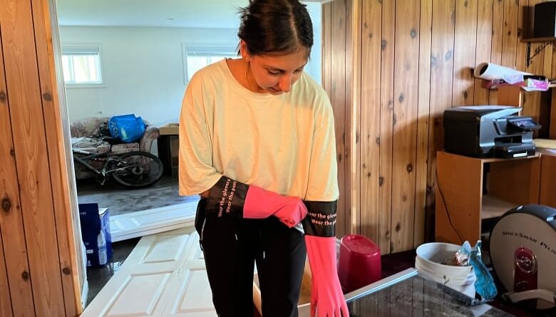 A woman pulls on cleaning gloves